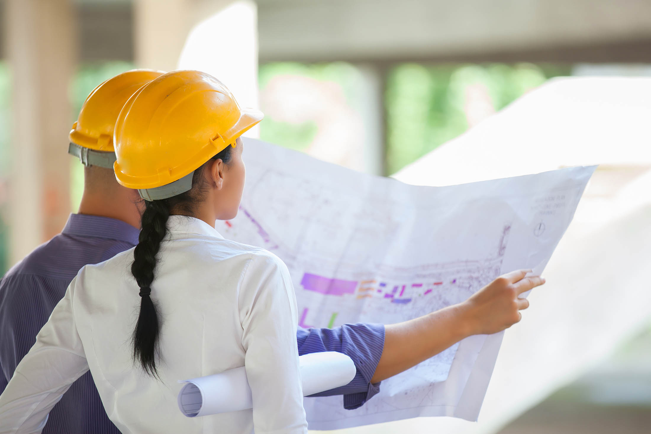 Architects and Builders on site at a house build, looking at plans.